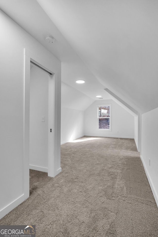 bonus room with carpet floors and vaulted ceiling