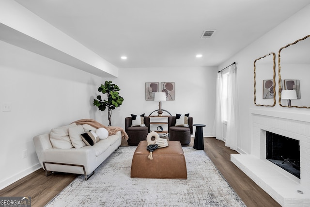 living room with hardwood / wood-style floors and a brick fireplace