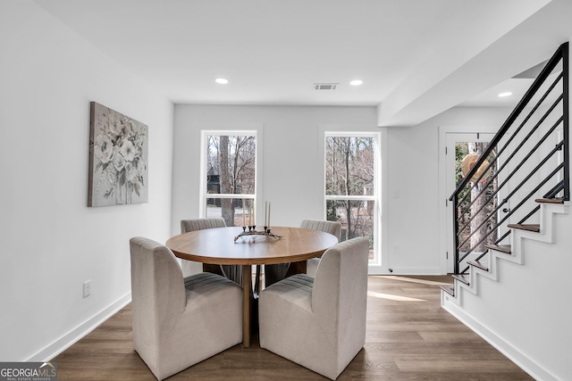 dining space with dark wood-type flooring and a healthy amount of sunlight