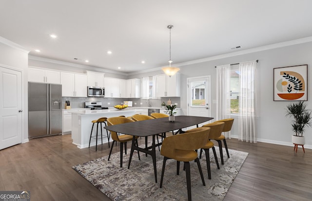 dining room with dark hardwood / wood-style floors and crown molding