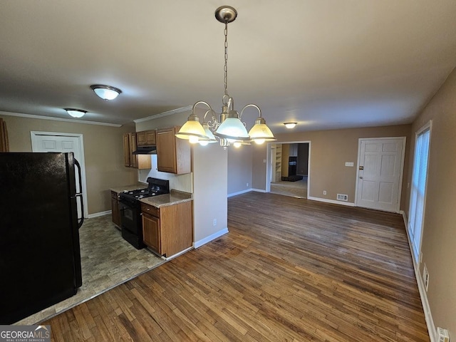 kitchen with black appliances, decorative light fixtures, dark hardwood / wood-style floors, a chandelier, and crown molding