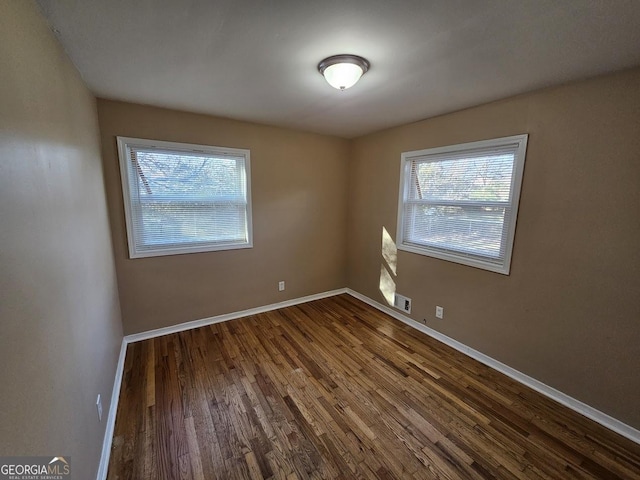 empty room with wood-type flooring and a healthy amount of sunlight