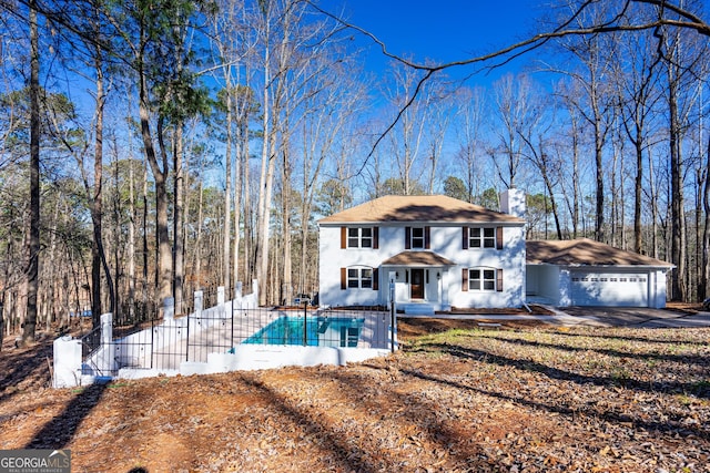 view of front of home featuring a fenced in pool, fence, a chimney, and a garage