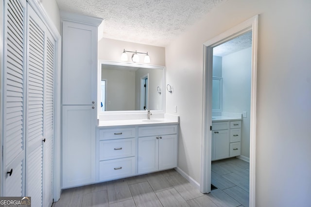 49 Post Oak Dr, Lagrange, GA 30240 - bathroom featuring a closet, vanity, a textured ceiling, baseboards, and wood tiled floors