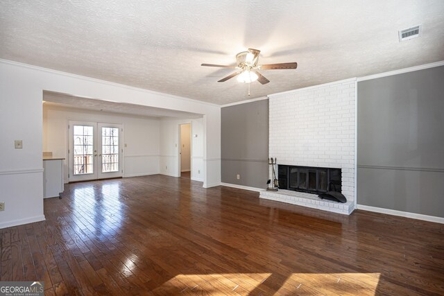 unfurnished living room featuring a textured ceiling, a fireplace, dark hardwood / wood-style floors, ornamental molding, and ceiling fan