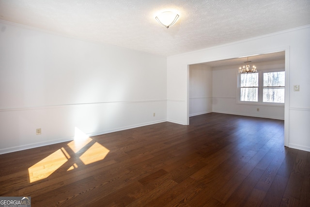 unfurnished room featuring a textured ceiling, dark wood-type flooring, a chandelier, and crown molding