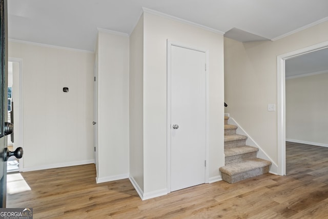 stairway with hardwood / wood-style flooring and crown molding