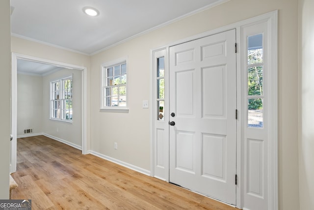 foyer with light wood-type flooring and crown molding