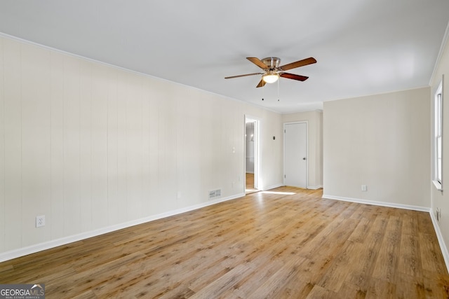 empty room with ceiling fan, ornamental molding, and light hardwood / wood-style floors