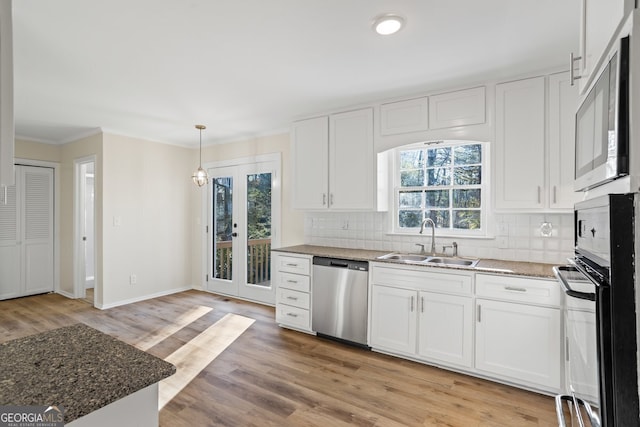 kitchen with light hardwood / wood-style floors, pendant lighting, sink, white cabinetry, and stainless steel appliances