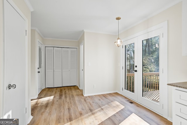 unfurnished dining area featuring light hardwood / wood-style floors, ornamental molding, and french doors