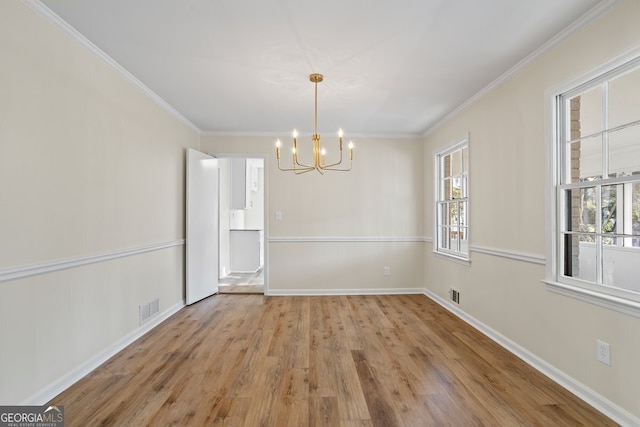 unfurnished dining area with light wood-type flooring, a notable chandelier, and crown molding