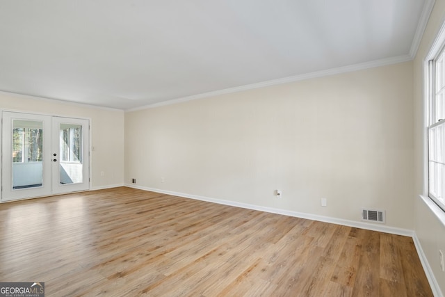 spare room featuring light wood-type flooring, french doors, and crown molding