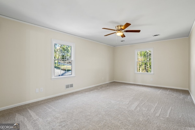 empty room featuring ceiling fan, crown molding, and carpet floors