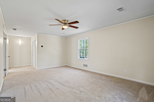 unfurnished room with ceiling fan, crown molding, and light colored carpet