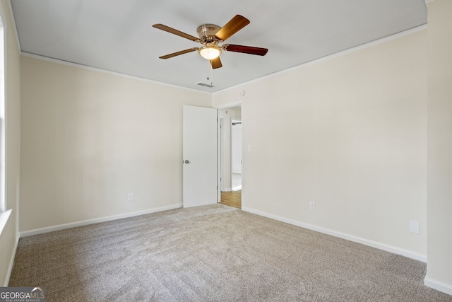 carpeted empty room with ceiling fan and ornamental molding