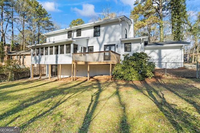 rear view of house with a wooden deck, a sunroom, and a yard