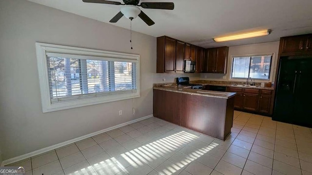 kitchen with sink, dark brown cabinetry, light tile patterned floors, and black appliances