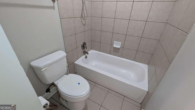 bathroom with toilet, tile patterned floors, and tiled shower / bath