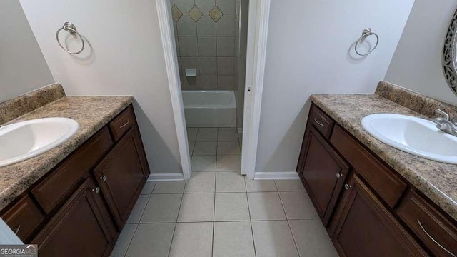 bathroom featuring tile patterned flooring, tiled shower / bath, and vanity