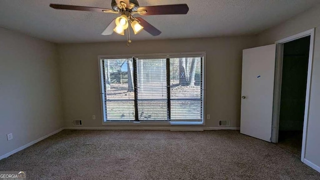 carpeted empty room featuring ceiling fan and a textured ceiling