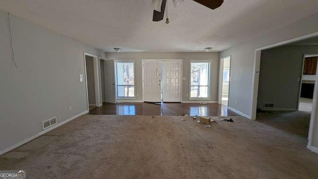 interior space with ceiling fan and a textured ceiling