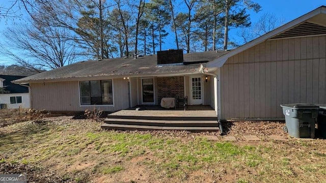 back of house featuring a deck and a lawn