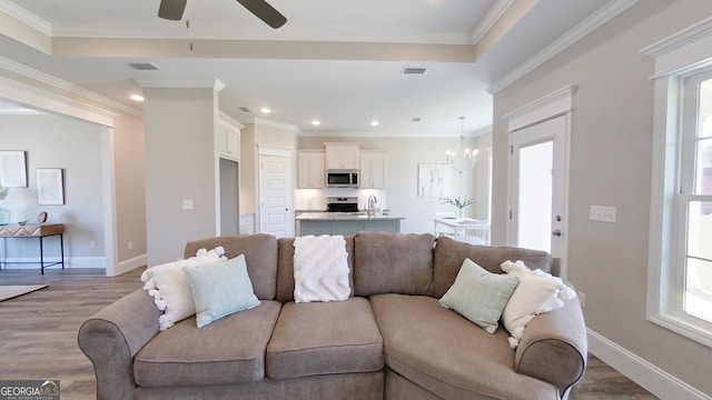 1013 Syrup Mill Creek Ln, Cairo, GA 39828 - living room featuring ceiling fan with notable chandelier, visible vents, and ornamental molding