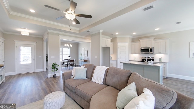1013 Syrup Mill Creek Ln, Cairo, GA 39828 - living area with visible vents, ceiling fan with notable chandelier, crown molding, and wood finished floors
