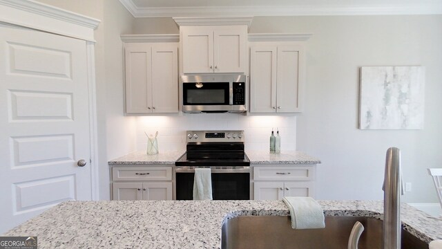 1013 Syrup Mill Creek Ln, Cairo, GA 39828 - kitchen featuring backsplash, white cabinets, stainless steel appliances, and crown molding