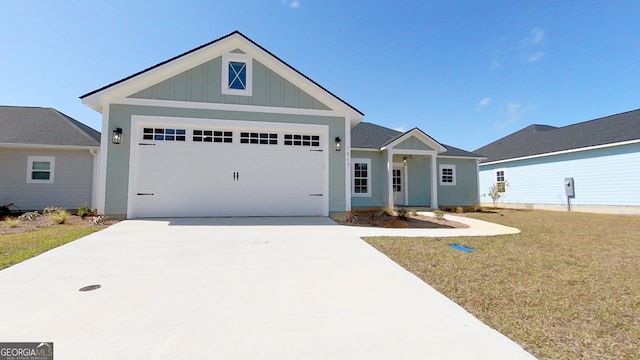 1013 Syrup Mill Creek Ln, Cairo, GA 39828 - view of front of home featuring a garage, board and batten siding, concrete driveway, and a front lawn