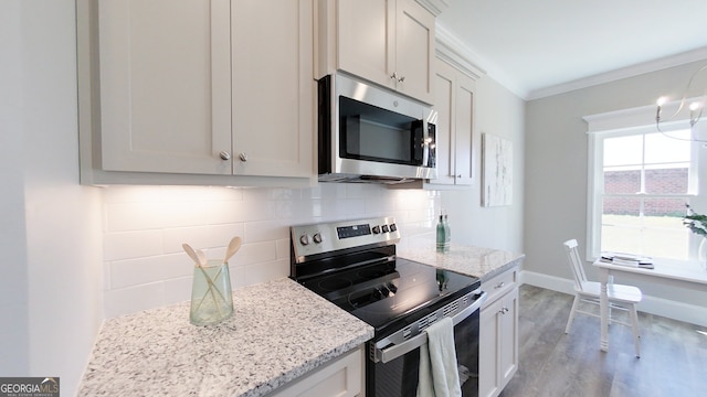 1013 Syrup Mill Creek Ln, Cairo, GA 39828 - kitchen featuring backsplash, light stone countertops, ornamental molding, light wood-style flooring, and appliances with stainless steel finishes