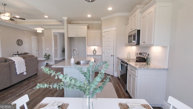1013 Syrup Mill Creek Ln, Cairo, GA 39828 - kitchen featuring backsplash, open floor plan, white cabinets, and stainless steel appliances