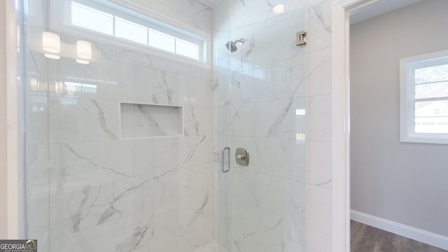 1013 Syrup Mill Creek Ln, Cairo, GA 39828 - full bathroom featuring wood finished floors, a healthy amount of sunlight, a stall shower, and baseboards
