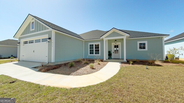 1013 Syrup Mill Creek Ln, Cairo, GA 39828 - view of front of home featuring board and batten siding, a front lawn, roof with shingles, driveway, and an attached garage