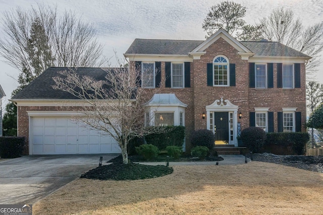 colonial-style house featuring a front yard and a garage