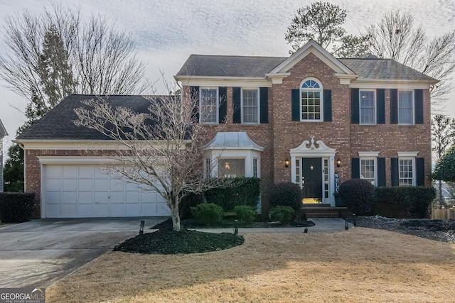 colonial inspired home with a garage and a front yard