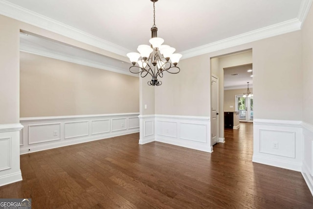 unfurnished dining area featuring dark hardwood / wood-style flooring, ornamental molding, and a chandelier