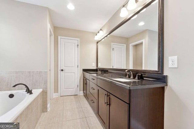 bathroom featuring vanity, tile patterned flooring, and tiled tub