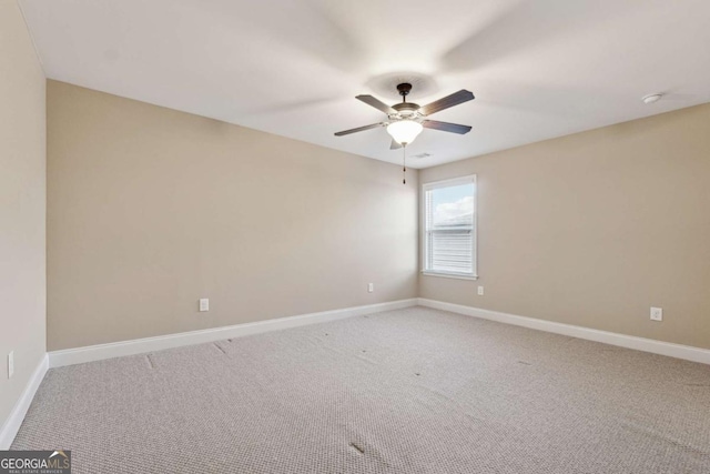 unfurnished room with ceiling fan and carpet