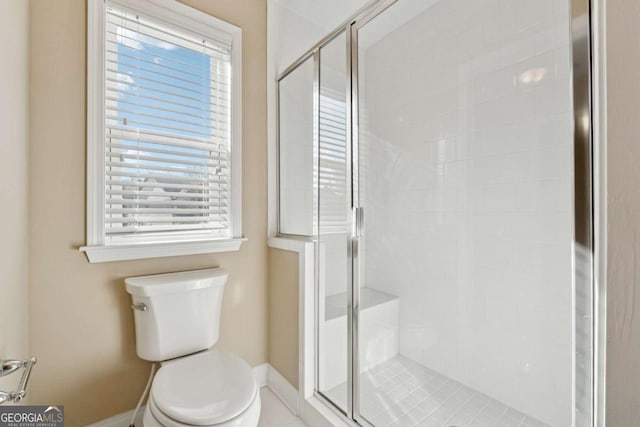 bathroom featuring toilet and a shower with shower door