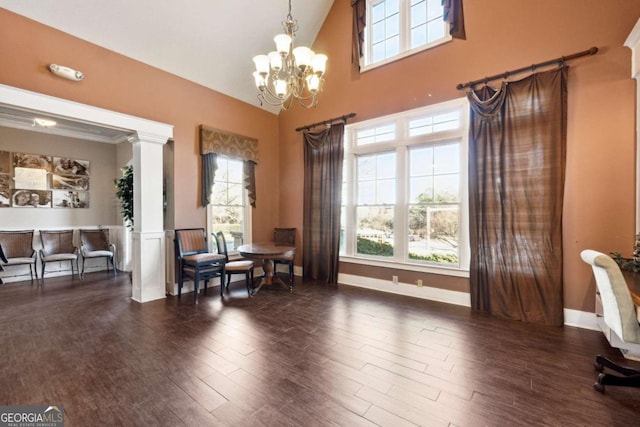 sitting room with dark hardwood / wood-style flooring, a healthy amount of sunlight, a towering ceiling, and a notable chandelier