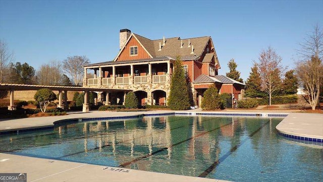 rear view of house featuring a patio area and a community pool