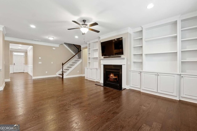 unfurnished living room featuring ceiling fan, dark wood-type flooring, and crown molding