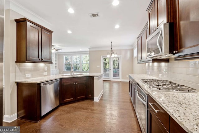 kitchen featuring decorative light fixtures, sink, stainless steel appliances, dark hardwood / wood-style flooring, and ceiling fan with notable chandelier