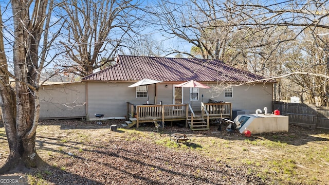 rear view of property featuring a wooden deck and cooling unit