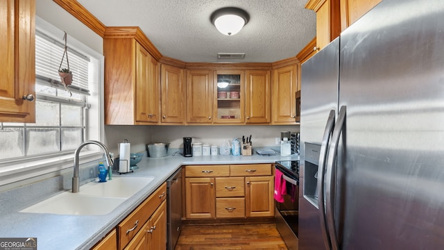 kitchen with dark wood-type flooring, sink, stainless steel appliances, and a textured ceiling