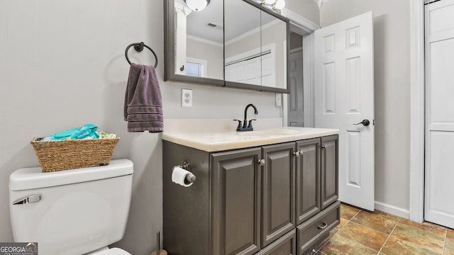 bathroom with toilet, vanity, and crown molding