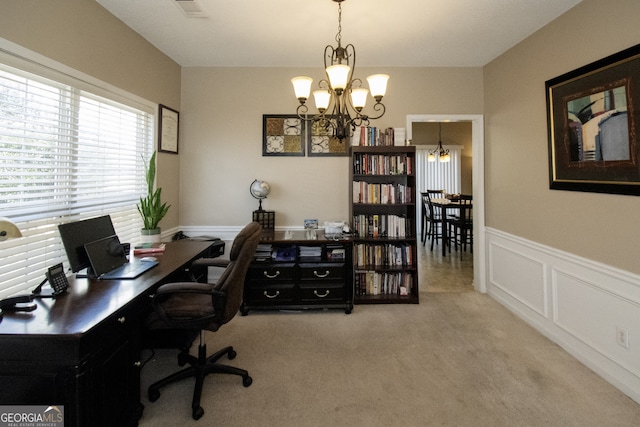 carpeted home office with an inviting chandelier