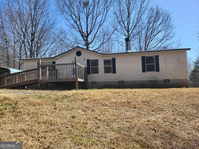 back of property featuring a carport and a wooden deck